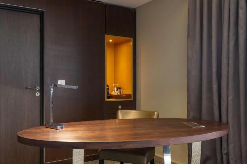 a room with a wooden table and a chair at Radisson Blu Okoume Palace Hotel, Libreville in Libreville