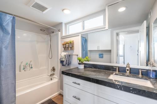 a bathroom with a sink and a shower and a tub at Ocean Breeze II by AvantStay Steps to the Beach in Newport Beach