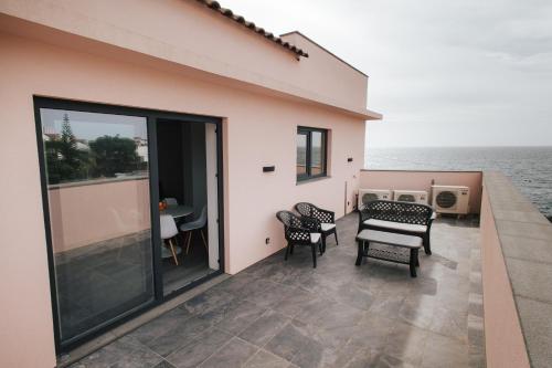 - un balcon avec des chaises, une table et de l'eau dans l'établissement Penthouse Seaside Apartment B - Faraway, à Lagoa