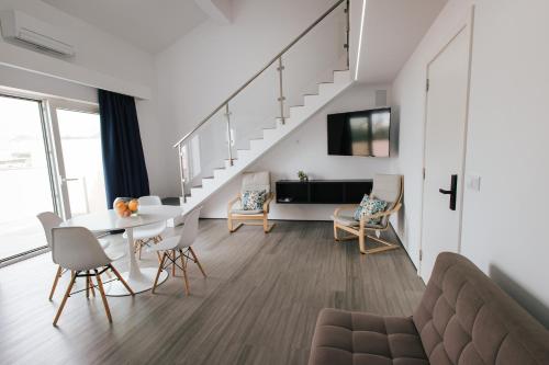 a living room with a dining table and a staircase at Penthouse Seaside Apartment B - Faraway in Lagoa
