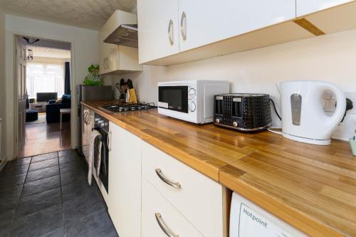 a kitchen with white cabinets and a wooden counter top at Liverpool City Haven-Dane Street in Liverpool