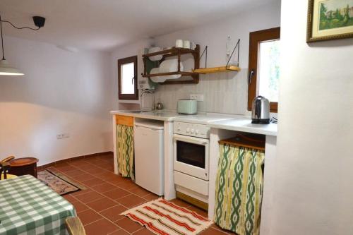 una cocina con electrodomésticos blancos y una mesa. en Cozy Apartment Downtown en Órgiva