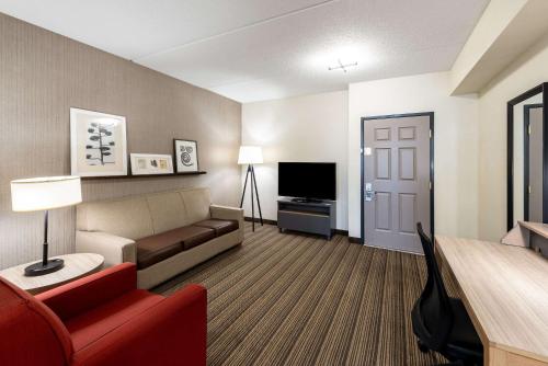 a living room with a couch and a television at Country Inn & Suites by Radisson, Findlay, OH in Findlay