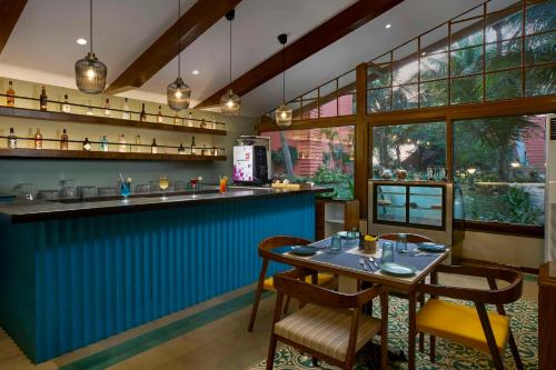 a restaurant with a blue bar with a table and chairs at Mandrem Beach Resort, a member of Radisson Individuals Retreat in Mandrem