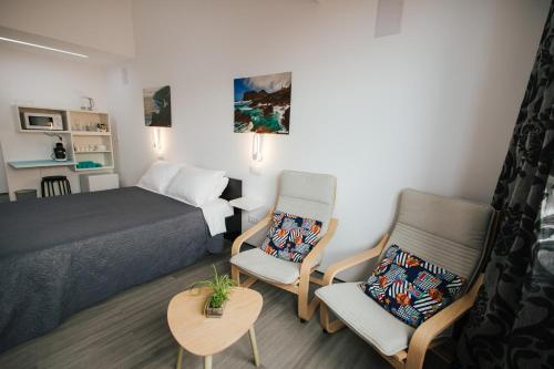 1 dormitorio con 1 cama, 2 sillas y mesa en Cozy Seaside Studio Apartment C - Faraway, en Lagoa
