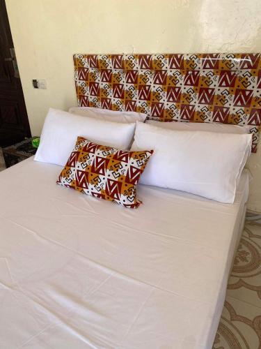 - un lit blanc avec 2 oreillers dans l'établissement Lovely 2bedeoom appartement in the heart of Nouakchott, à Nouakchott