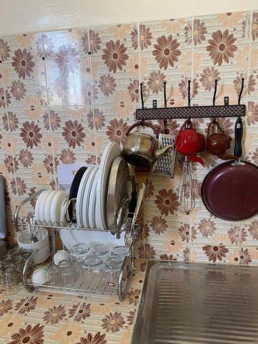 un comptoir de cuisine avec des plaques et des casseroles sur un mur dans l'établissement Lovely 2bedeoom appartement in the heart of Nouakchott, à Nouakchott