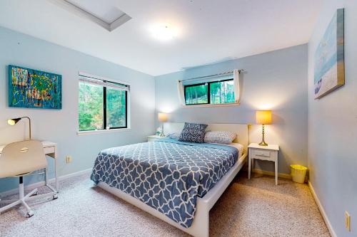 a bedroom with a bed and a desk and two windows at The Garden Home in Issaquah