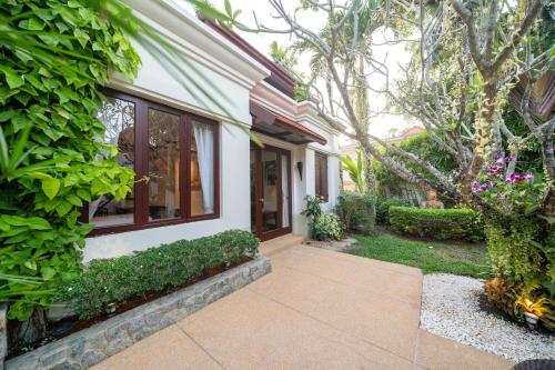 a walkway leading to a house with plants at Saitaan Villa Dennapa Bang Tao Beach in Bang Tao Beach