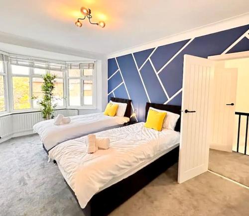 two beds in a large room with blue walls at Wembley wow house in Preston