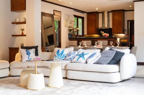 a living room with two couches and a table at Saitaan Villa Dennapa Bang Tao Beach in Bang Tao Beach