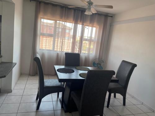 a dining room with a table and chairs and a window at 3The Olive Complex Richards Bay 3900 in Richards Bay