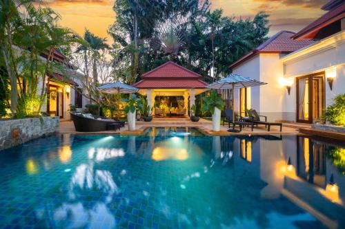 a swimming pool in front of a house at Saitaan Villa Dennapa Bang Tao Beach in Bang Tao Beach