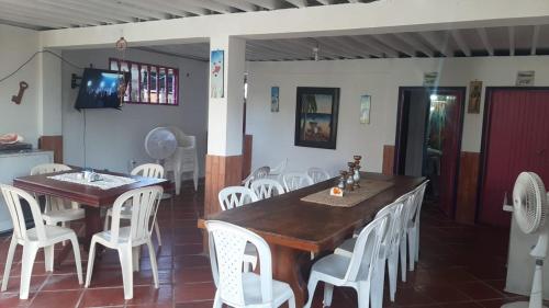 a dining room with a table and white chairs at Milimar Hostal in San Onofre