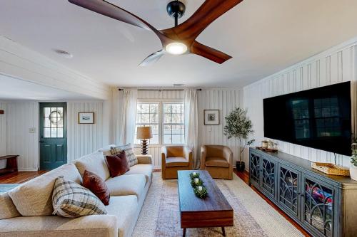 a living room with a couch and a flat screen tv at The Lakeway House in Buford