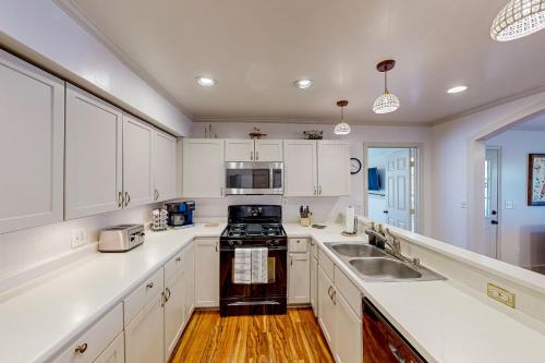 a kitchen with white cabinets and a sink at The Lakeway House in Buford