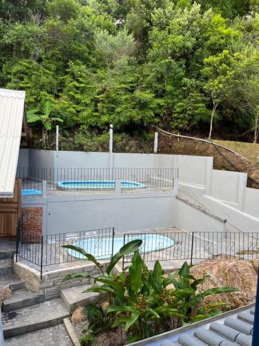 a swimming pool in a backyard with a fence at Pousada Maikai Garden in Porto Belo