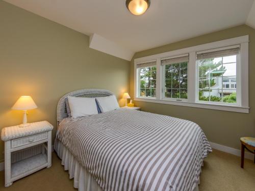 a bedroom with a bed and two windows at Becalmed MCA#1653 in Manzanita