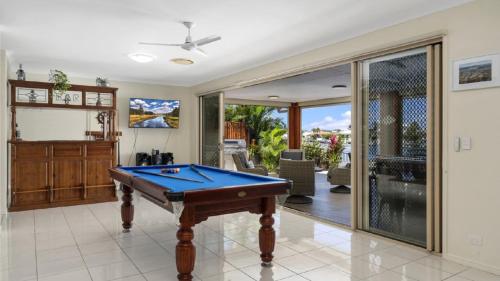 a pool table in a room with a patio at Bribie Bliss: Luxe Canal Living in Banksia Beach