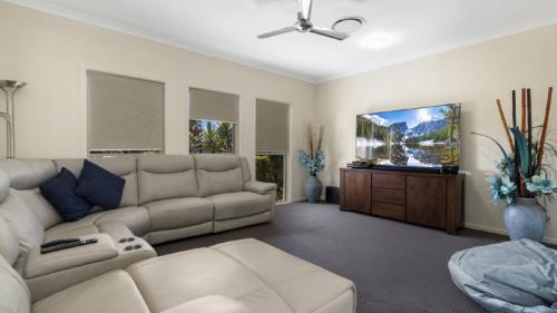 a living room with a couch and a flat screen tv at Bribie Bliss: Luxe Canal Living in Banksia Beach