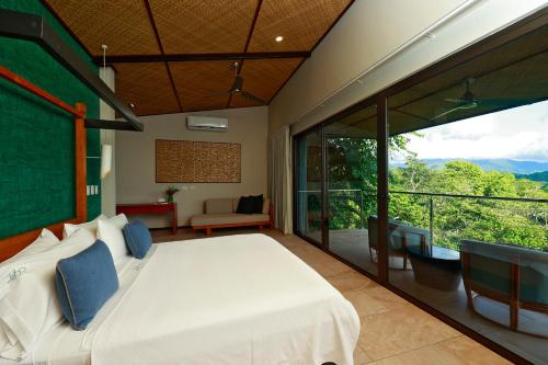 ein Schlafzimmer mit einem großen Bett und einem Balkon in der Unterkunft Hotel Three Sixty - Adults Only in Ojochal