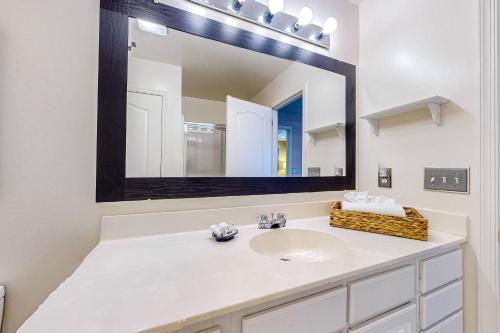 a bathroom with a sink and a large mirror at The Palms --- 36507 Palm Dr #2102 in Rehoboth Beach