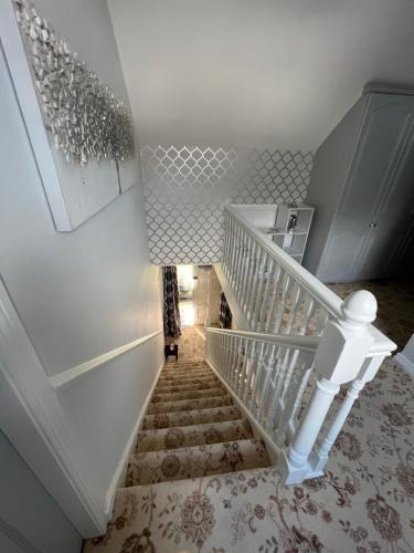a white staircase with white railings and a white wall at Fair Green B&B in Ballygawley