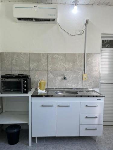 cocina blanca con fregadero y microondas en DEPARTAMENTOS A METROS DE LA UNAF en Formosa