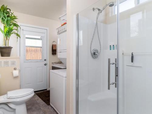 a white bathroom with a shower and a toilet at Reno Studio Gem: Cozy Netflix Free Parking in Reno