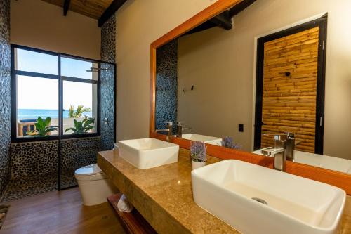un bagno con due lavandini e una grande finestra di Casa Colibrí a Máncora