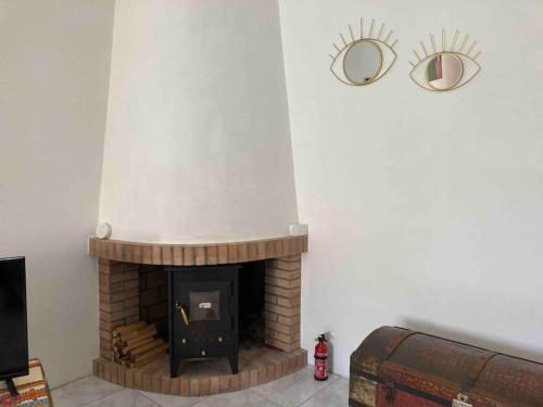 einen Kamin im Wohnzimmer mit zwei Spiegeln an der Wand in der Unterkunft Casa Tranquila Barrada in Alcoutim
