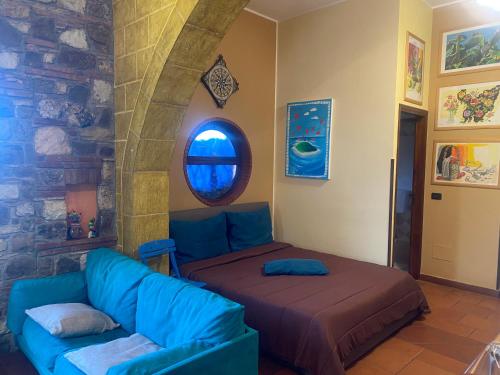 Una sala de estar con un sofá y una ventana. en Loft Sul Mare, en Balestrate