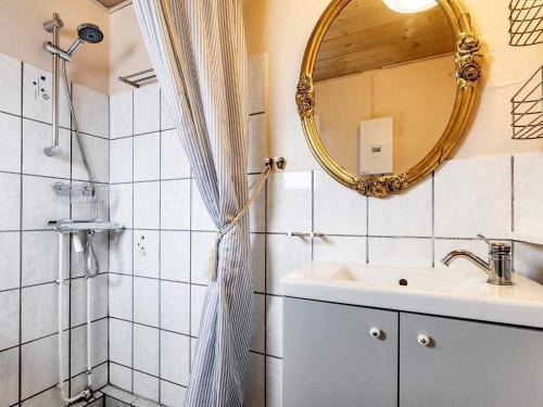 uma casa de banho com um lavatório e um espelho em Holiday home Karrebæksminde XLIV em Karrebæksminde