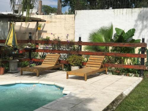 un patio avec deux chaises et une piscine dans l'établissement FINCA URBANA departamentos, à Alta Gracia