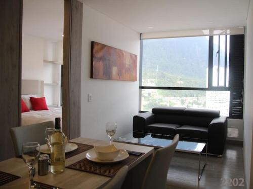 16 Torre Barcelona Apartment, City Center في بوغوتا: غرفة طعام مع طاولة وأريكة