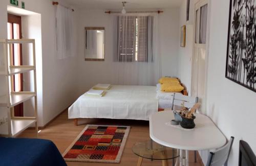 Cette petite chambre comprend un lit et une table. dans l'établissement Apartments by the sea Basina, Hvar - 4620, à Basina