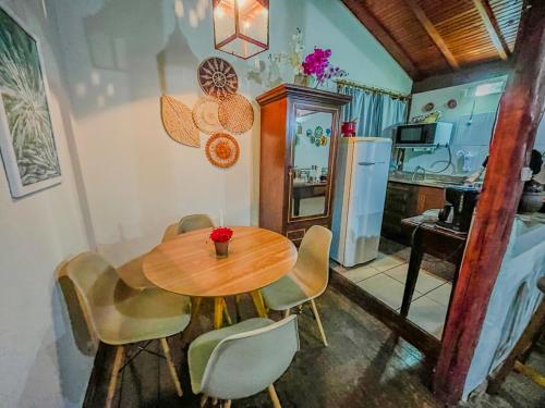 a kitchen with a wooden table and chairs in a kitchen at CHALÉ ADOBE in Carrancas