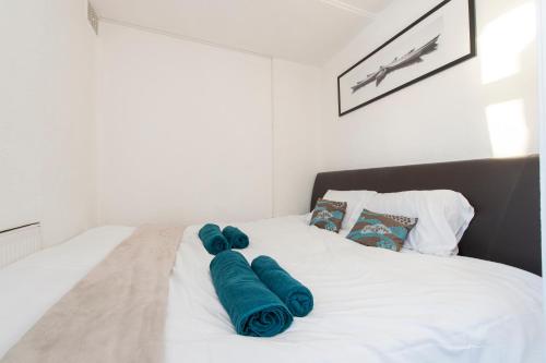 Una cama blanca con toallas azules. en Harwich haven great for couples and contractors en Harwich