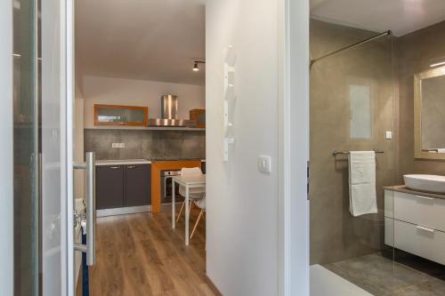 ein Bad mit einer Dusche, einem Waschbecken und einem Tisch in der Unterkunft Apartments and rooms with parking space Njivice, Krk - 17010 in Njivice