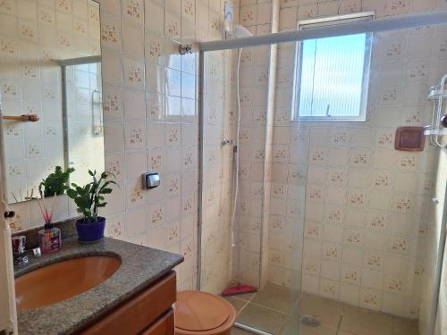 La salle de bains est pourvue d'un lavabo et d'une douche. dans l'établissement Nosso amor em paz, à Praia Grande