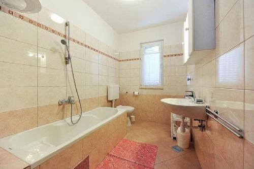 ein Badezimmer mit einer Badewanne und einem Waschbecken in der Unterkunft Apartments with a parking space Zadar - 22541 in Zadar