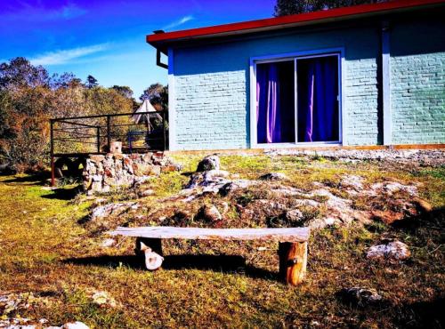 a bench in front of a building with a window at Alma Mía in Villa Serrana