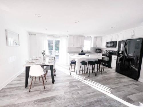 a white kitchen with a table and some chairs at Cozy Getaway Lodge & Retreat in Mechanicsburg