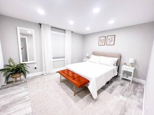 a white bedroom with a bed and a bench at Cozy Getaway Lodge & Retreat in Mechanicsburg