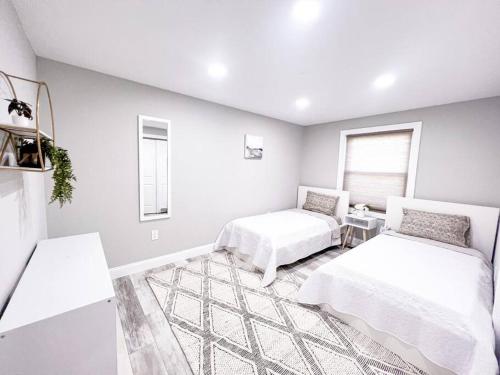 a white room with two beds and a window at Cozy Getaway Lodge & Retreat in Mechanicsburg