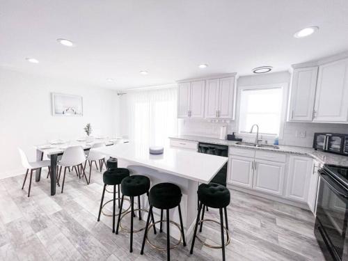 a kitchen with white cabinets and a white table and stools at Cozy Getaway Lodge & Retreat in Mechanicsburg
