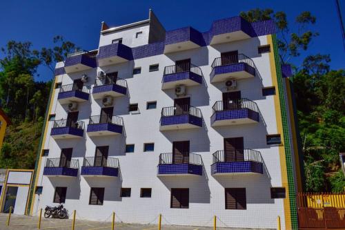 Apartamentos e Flats Praia das Toninhas - Ubatuba في أوباتوبا: مبنى فيه بلكونات جنبه