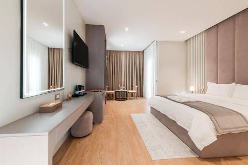 a bedroom with a large bed and a television at Troci Hotel in Tirana