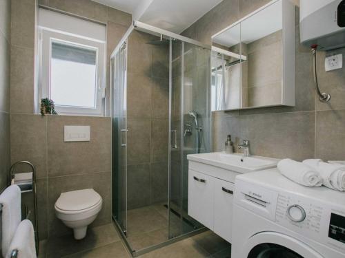 La salle de bains est pourvue de toilettes, d'une douche et d'un lavabo. dans l'établissement Apartments with a parking space Trogir - 22615, à Trogir