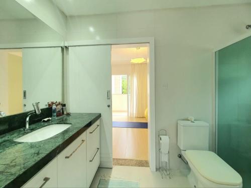 uma casa de banho com um lavatório e um WC em Demi-suíte privativa em casa familiar 2 em Itajaí
